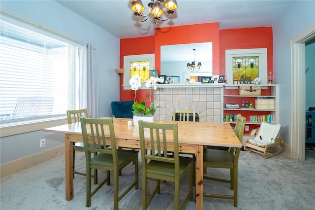 dining area featuring a fireplace, a healthy amount of sunlight, an inviting chandelier, and carpet flooring