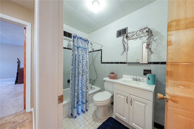 full bathroom with vanity, shower / bath combination with curtain, tile walls, and toilet