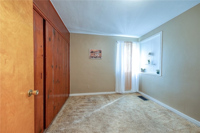 unfurnished room featuring light colored carpet