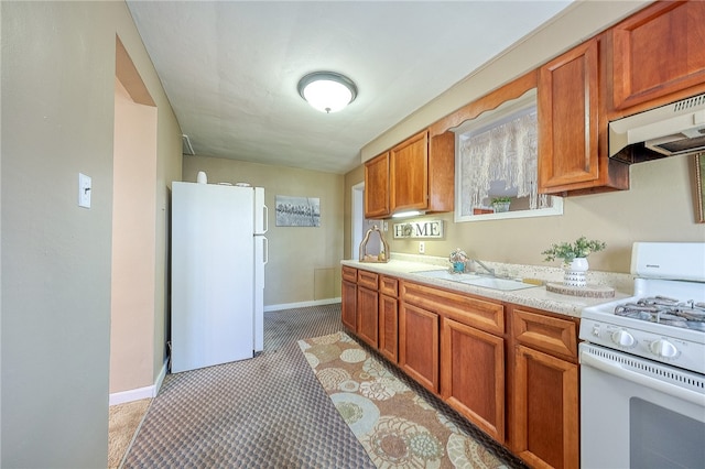 kitchen featuring sink, white appliances, and range hood