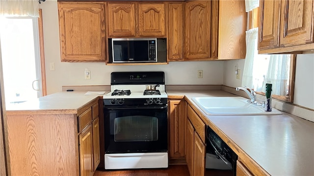 kitchen featuring dishwasher, sink, and white gas range oven