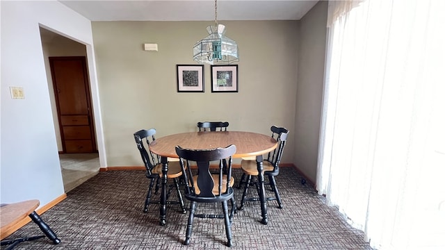 carpeted dining space with a notable chandelier