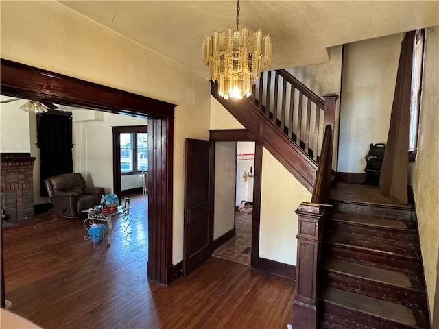 stairs with a notable chandelier and hardwood / wood-style flooring