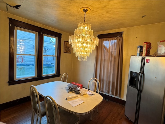 dining space with dark wood-type flooring and a notable chandelier