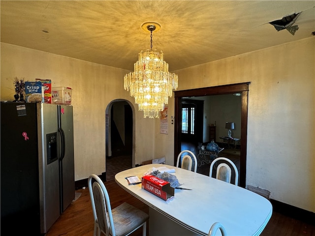 dining space featuring dark hardwood / wood-style floors and a chandelier