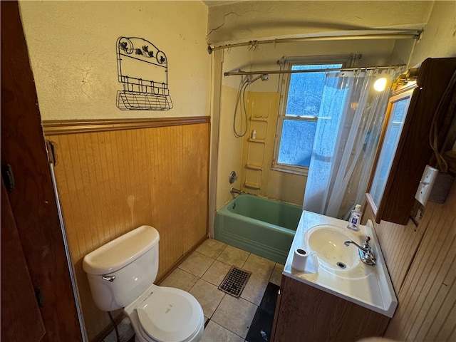 full bathroom with tile patterned flooring, wooden walls, toilet, shower / bath combo with shower curtain, and vanity