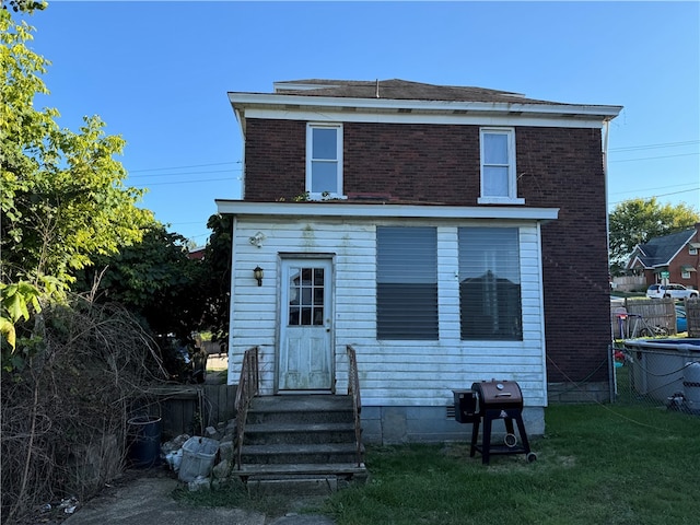 rear view of house featuring a yard