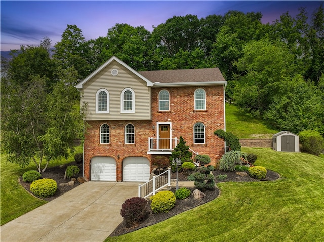 view of front of house featuring a storage unit, a garage, and a lawn