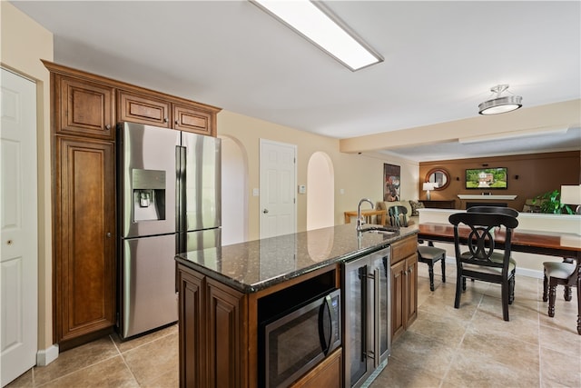 kitchen featuring wine cooler, black microwave, a kitchen island, stainless steel refrigerator with ice dispenser, and sink