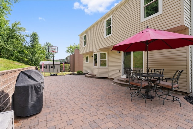 view of patio featuring a storage unit and a grill