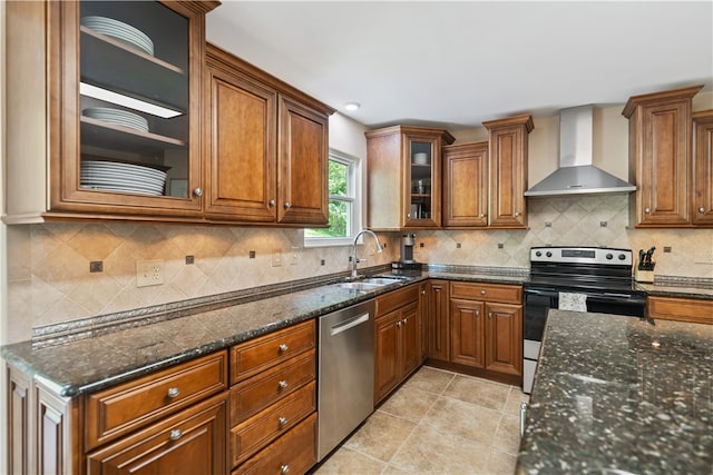 kitchen with wall chimney range hood, decorative backsplash, sink, and appliances with stainless steel finishes