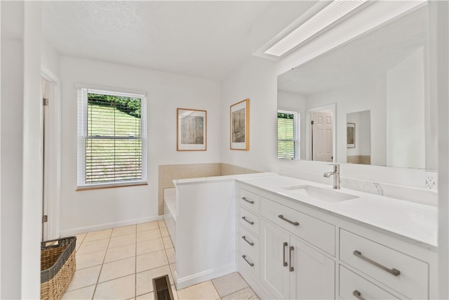 bathroom featuring vanity, a tub to relax in, and tile patterned floors