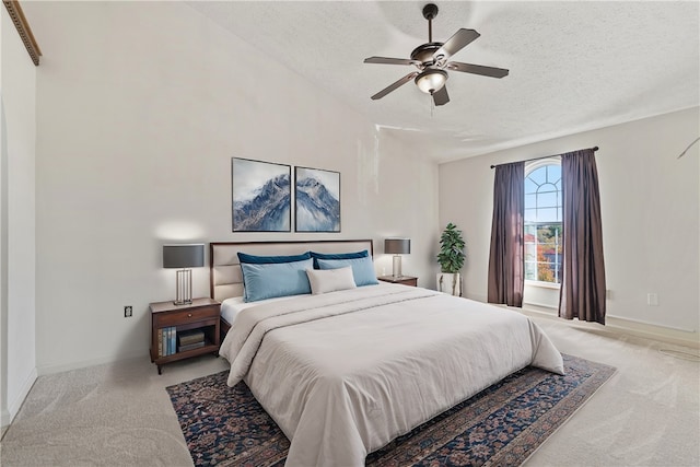 bedroom with a textured ceiling, light colored carpet, and ceiling fan