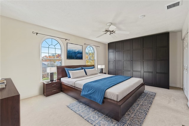 carpeted bedroom with a closet and ceiling fan