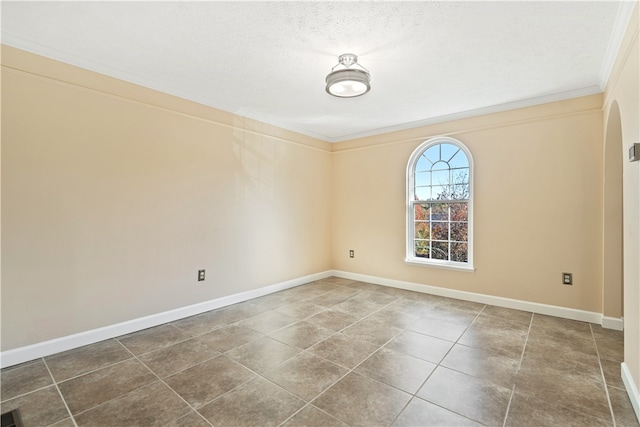 tiled empty room featuring crown molding and a textured ceiling