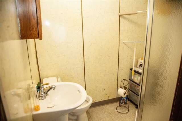 bathroom featuring toilet, sink, and tile patterned floors