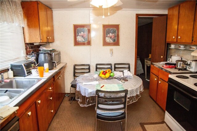 kitchen with white range, crown molding, dark tile patterned floors, sink, and stainless steel dishwasher