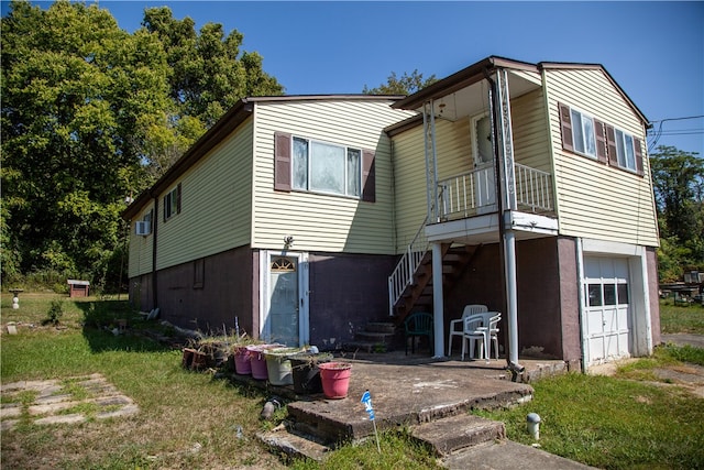 back of house featuring a yard and a garage