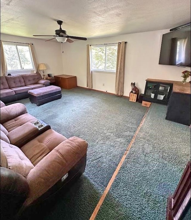 carpeted living room featuring ceiling fan, a wealth of natural light, and a textured ceiling