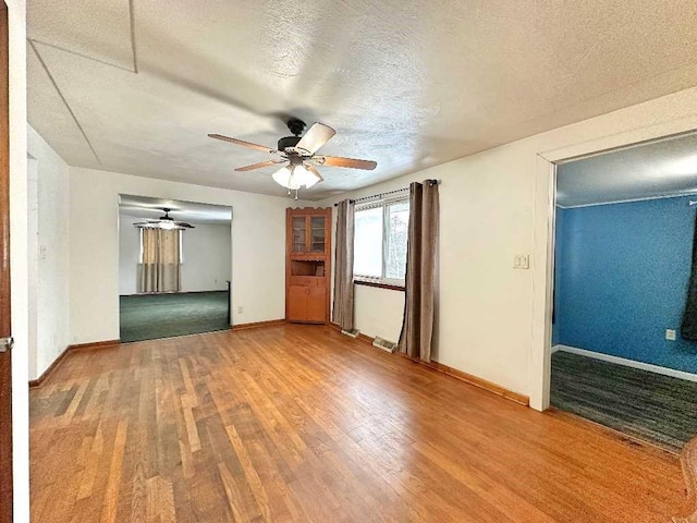 interior space featuring hardwood / wood-style flooring, ceiling fan, and a textured ceiling