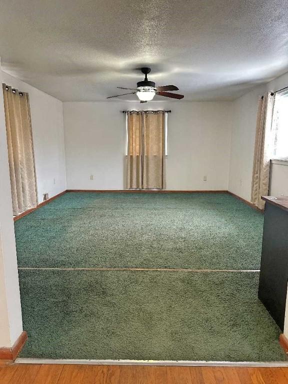 spare room featuring hardwood / wood-style flooring, ceiling fan, and a textured ceiling