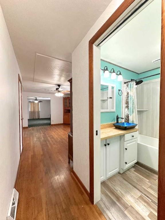 corridor with sink and light hardwood / wood-style floors