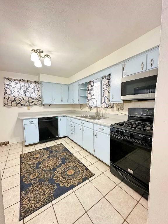 kitchen featuring light tile patterned flooring, sink, a textured ceiling, and black appliances