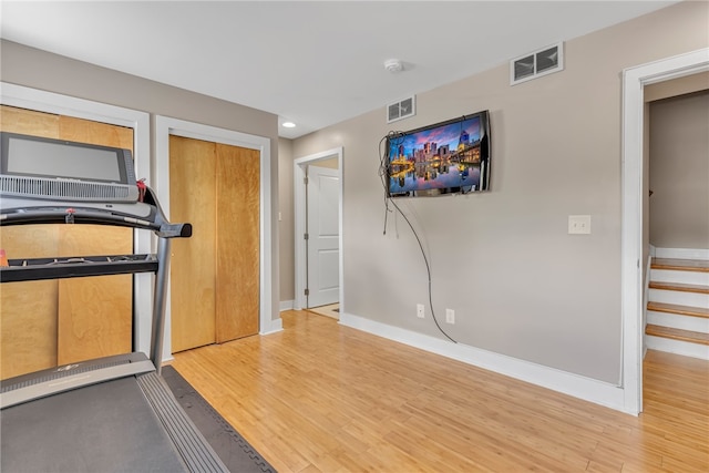 exercise room with light hardwood / wood-style flooring