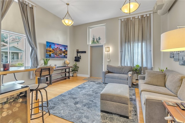 living room with an AC wall unit and hardwood / wood-style flooring