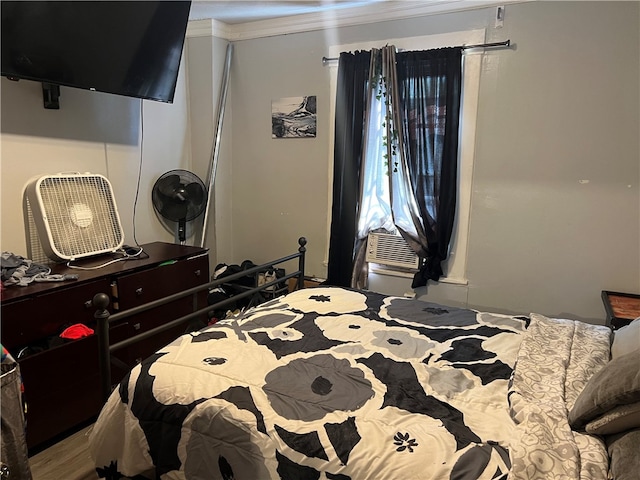 bedroom featuring ornamental molding and hardwood / wood-style flooring