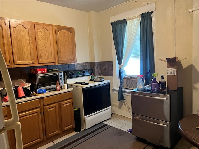 kitchen with light tile patterned floors, white range with electric cooktop, and stainless steel refrigerator