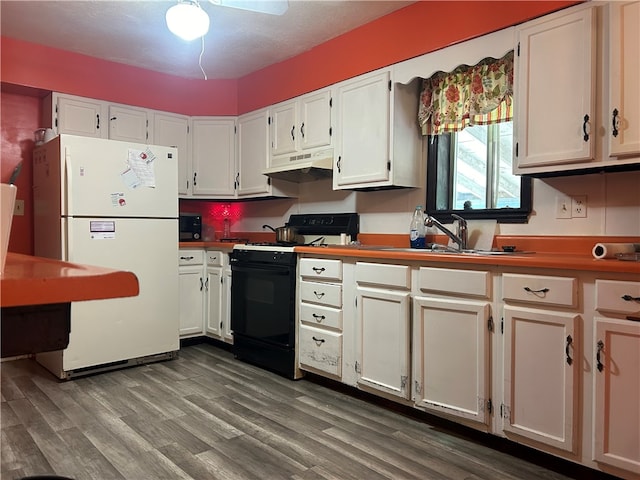 kitchen with black appliances, wood-type flooring, sink, and white cabinets