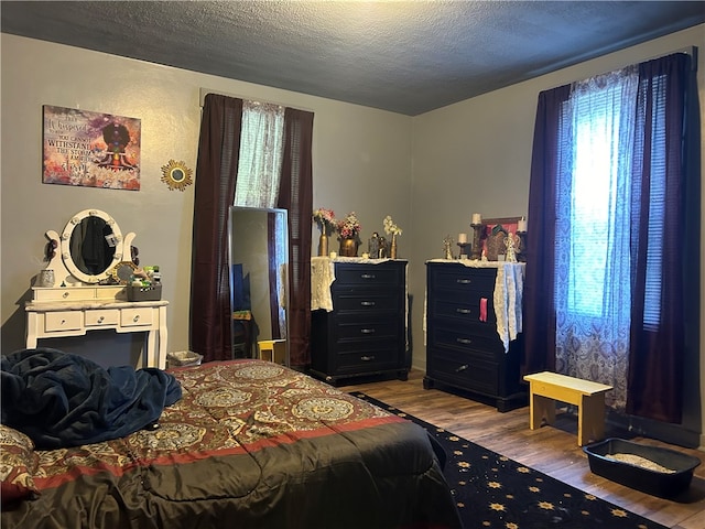 bedroom featuring hardwood / wood-style floors and a textured ceiling