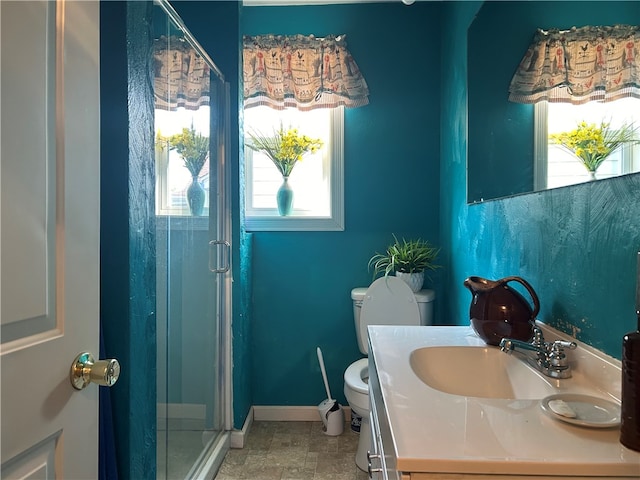 bathroom with vanity, toilet, and a shower with shower door