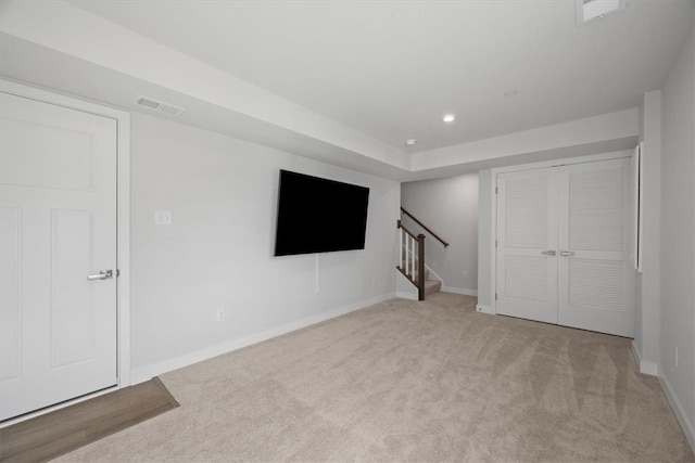 basement featuring light carpet