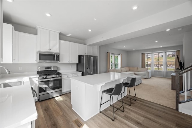 kitchen with white cabinetry, stainless steel appliances, sink, and dark hardwood / wood-style floors