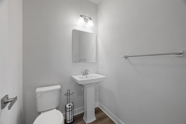 bathroom featuring toilet and wood-type flooring