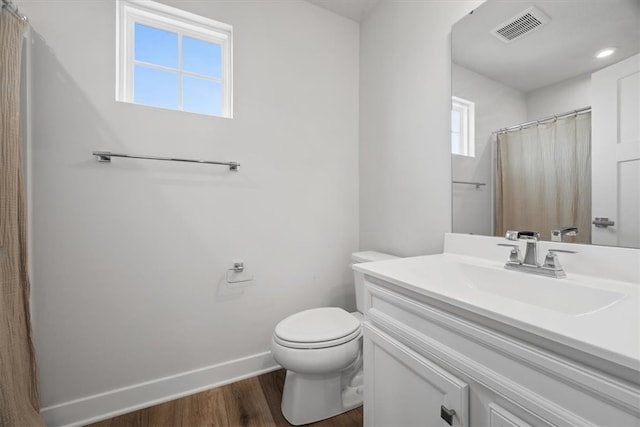 bathroom with vanity, toilet, a wealth of natural light, and wood-type flooring