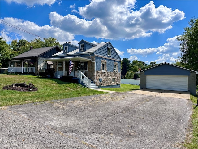 view of front of house with a garage, an outdoor structure, covered porch, and a front yard