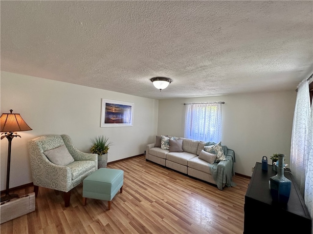 living room with a textured ceiling and light hardwood / wood-style flooring