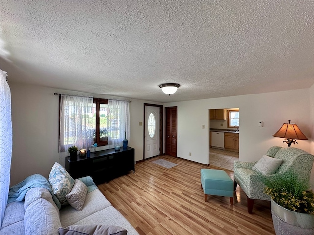 living room featuring a textured ceiling, sink, and light hardwood / wood-style floors