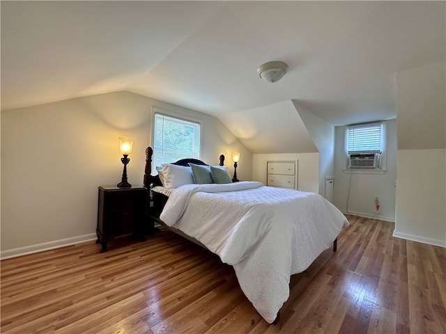 bedroom with light wood-type flooring and lofted ceiling