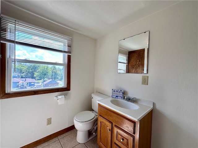 bathroom with tile patterned flooring, toilet, plenty of natural light, and vanity