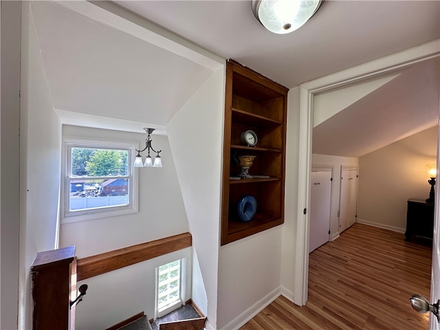 hall featuring hardwood / wood-style floors and a chandelier