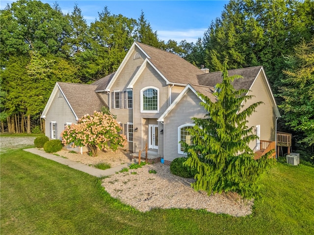 view of front of property with a front yard, cooling unit, and a wooden deck