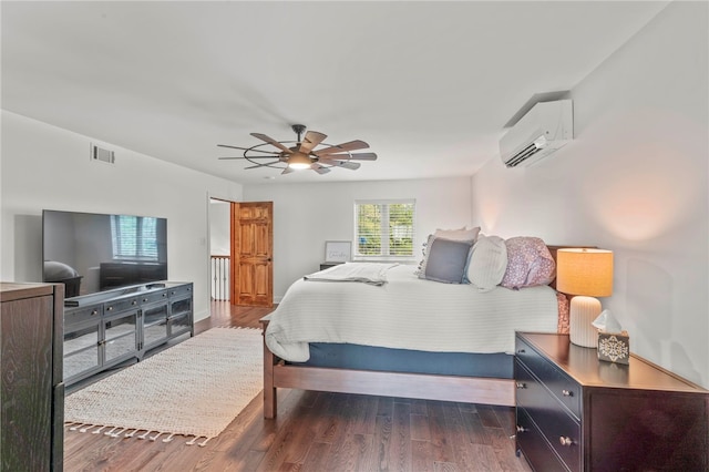 bedroom with dark wood-type flooring, ceiling fan, and a wall mounted air conditioner