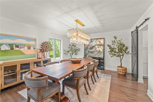 dining space with crown molding, a chandelier, a barn door, and dark hardwood / wood-style floors