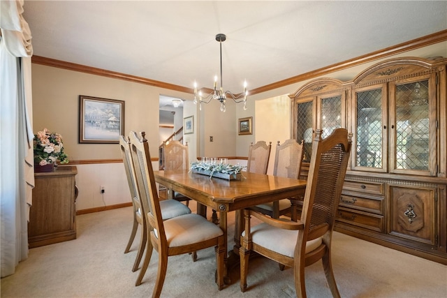 dining space with ornamental molding, light carpet, and an inviting chandelier