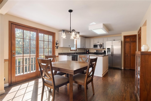 dining area with dark hardwood / wood-style flooring, a chandelier, and sink