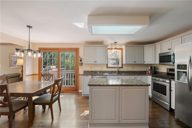 kitchen featuring decorative light fixtures, dark wood-type flooring, stainless steel appliances, and a chandelier